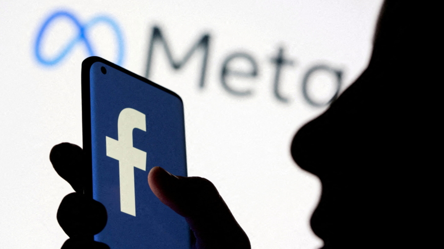 FILE PHOTO: A woman holds smartphone with Facebook logo in front of a displayed Facebook's new rebrand logo Meta in this illustration picture taken October 28, 2021. REUTERS/Dado Ruvic/Illustration/File Photo